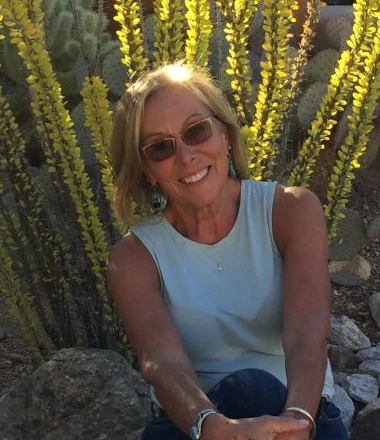 Meredith Davis seated outdoors in a desert garden